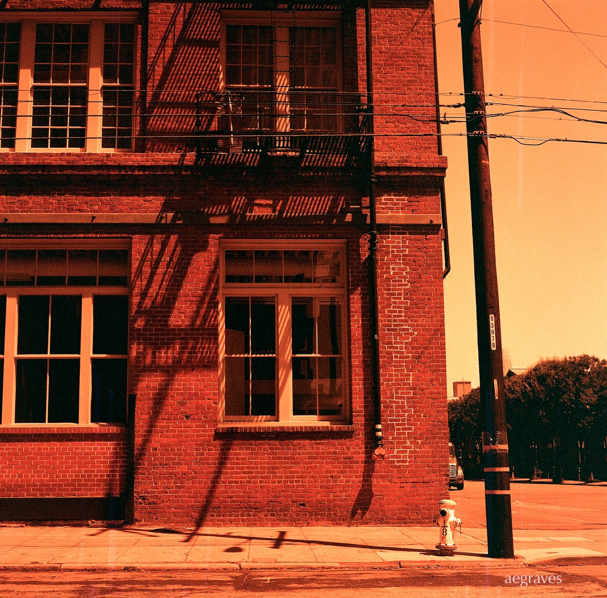 Red tinted image of brick industrial building corner