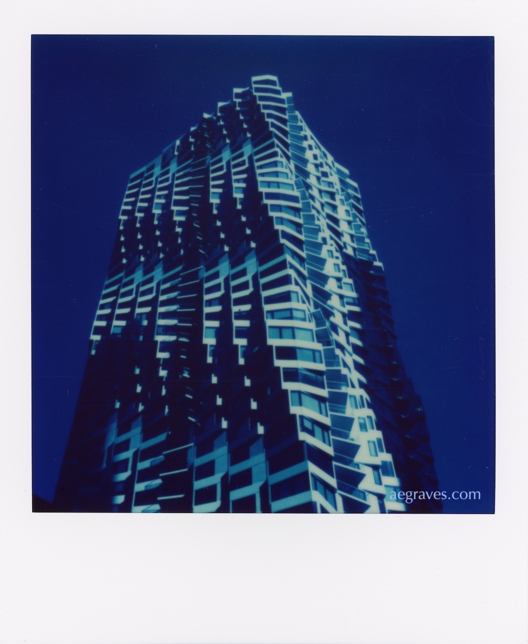 Blue, black, and white photo of a highly serrated building called MIRA in San Francisco