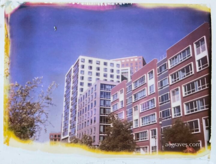 Color image with irregular edges of sunlit high-rise buildings along Mission Creek in SF