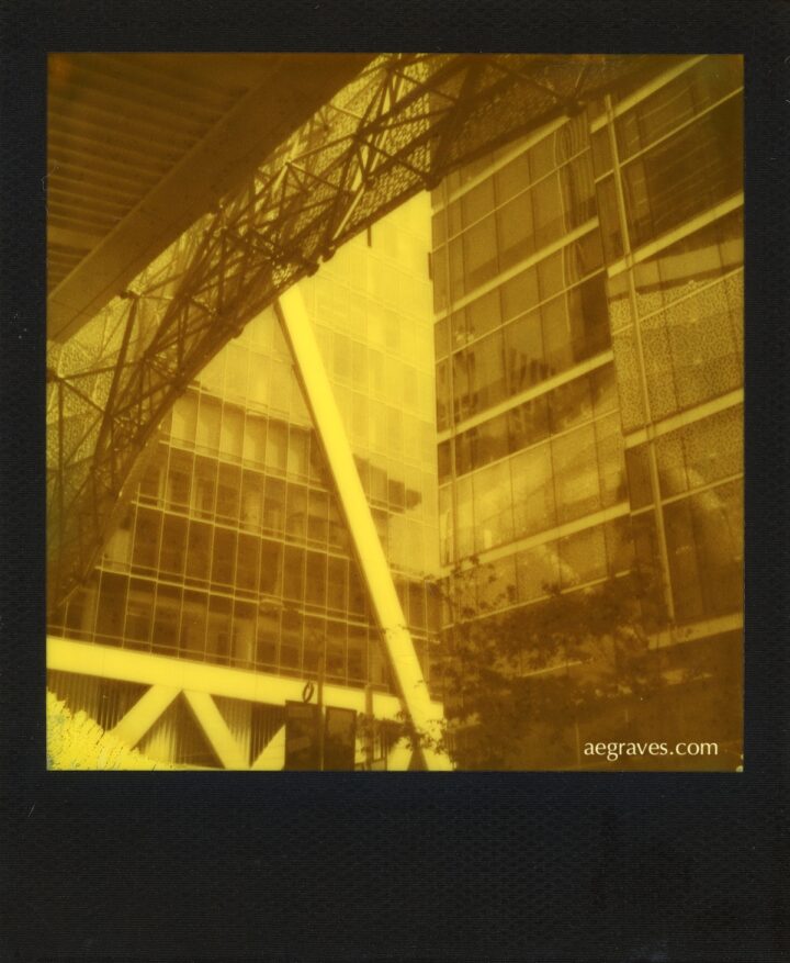 A black and yellow image of reflective buildings and diagonal lines