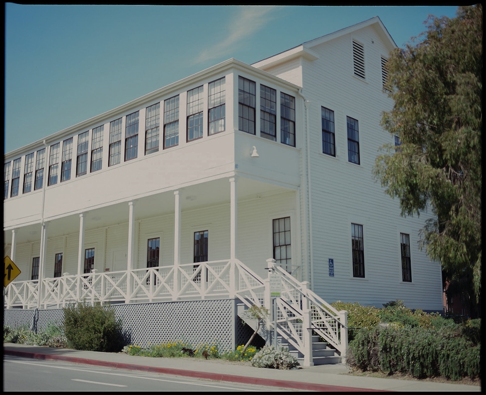 Historic building at Presidio Main post shown at the shaded end; covered porch below, enclosed covered extension above