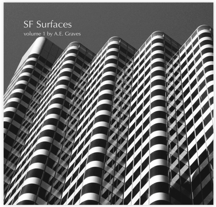 Black and white image of a highly reflective, striped building with five corners protruding into space by A.E. Graves