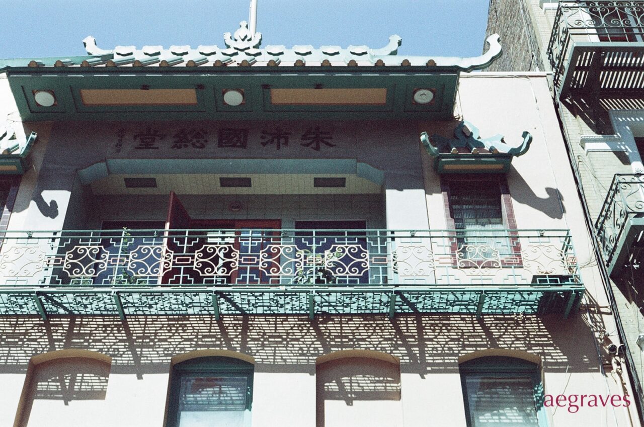 Ornate facade with a multicolored red and green metalwork balcony
