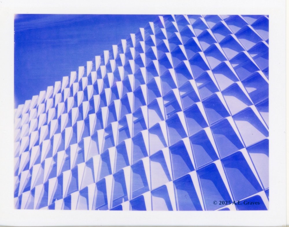 Blue toned image of a repetitive facade reflecting different shades of blue