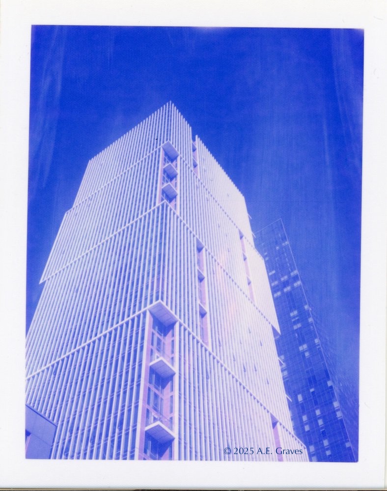 Blue toned image of a toler with vertical stripes and inset multi-storey balconies