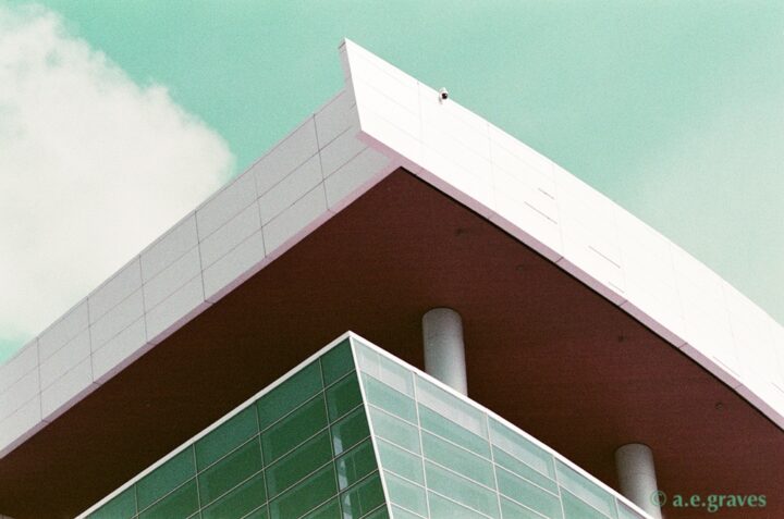 Chase Center architectural roof overhang detail with teal sky, diagonal corner, and hidden patio with columns