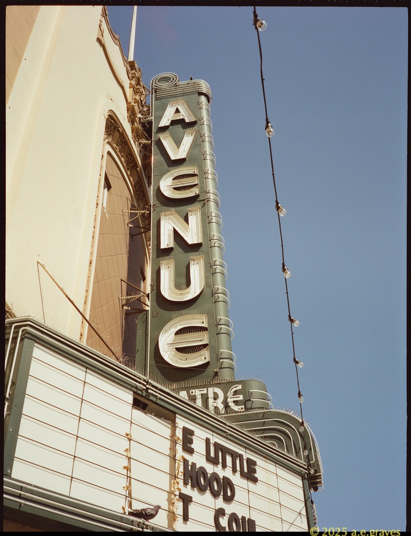 Avenue Marquee up close, with the neon letters backed with white and enclosed in shaped metal on the green sign clearly visible
