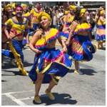 Dancers in yellow, fuschia, and royal blue performing in Carnaval