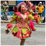 Woman in a lime green and pink costume performing at Carnaval