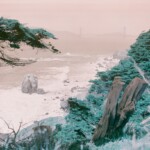 Turquoise hillside and orange sky and by with the Golden Gate Bridge barely visible in the far, misty distance