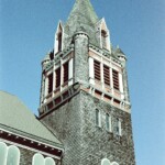 Shingled wooden church tower with red louvers