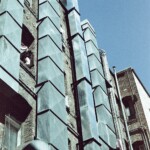 Vertical image of ventilation ducts on a brick building