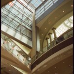 Interior view of skylights, reflections, and corners where a rectilinear atrium adjoins a circular one