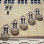 Five ornate balconie on the gold-yellow brick exterior of the Golden Gate Theater