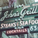 Neon sign for John's Grill Stakes & Seafood Cocktails 63