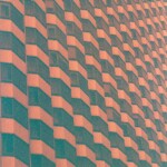 Orange and green image of a vast, faceted wall