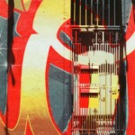 A red and gold mural continues through a metal barred door