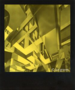 Monochrome black and yellow Polaroid image of a highly geometric but irregular metal patio roof