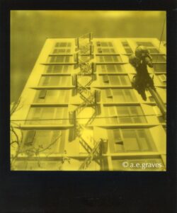 Monochrome black and yellow Polaroid image of an art installation of a dangerous-looking stairwell on the front of a contemporary building